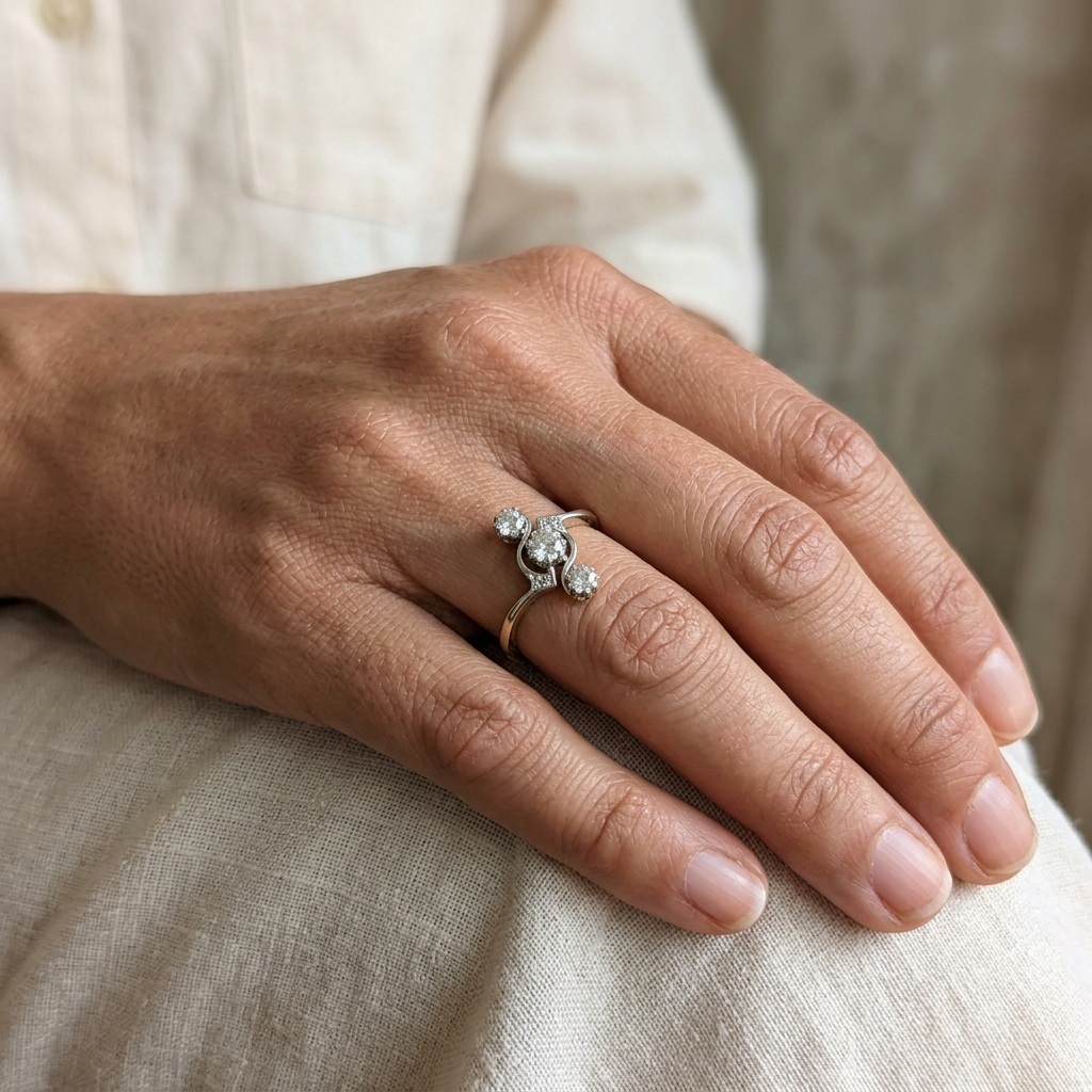 R2448 three-diamond yellow gold swirl ring worn on a hand