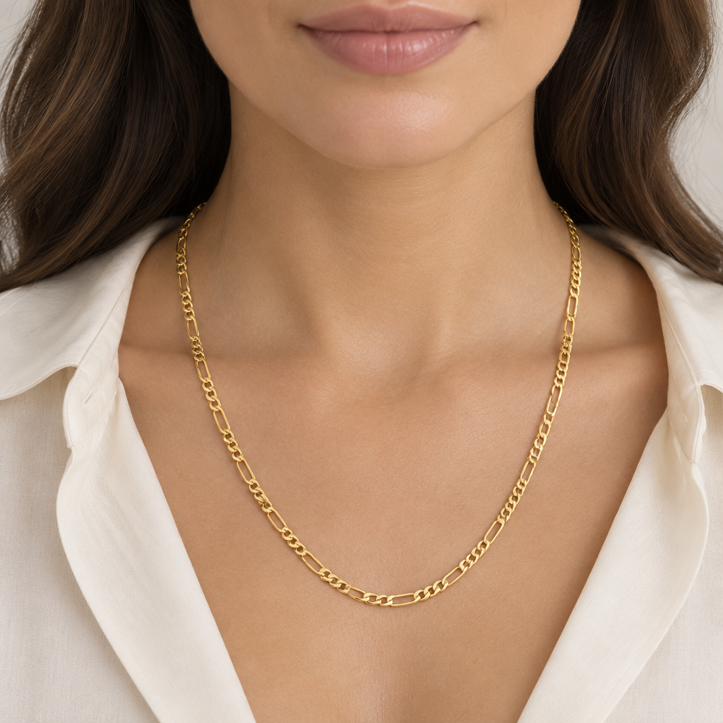 Woman wearing a 20 inch 10K yellow gold Figaro chain with a cream blouse