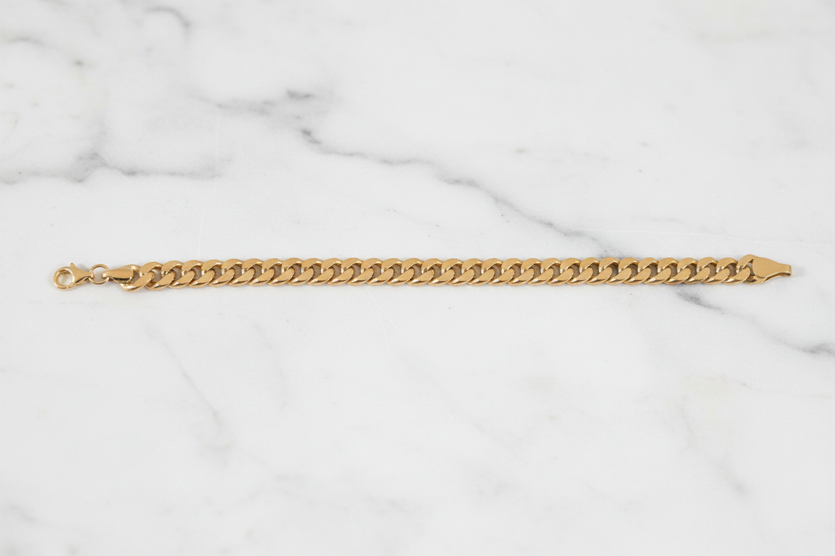 10K Yellow Gold Cuban Link Bracelet flat lay on white marble