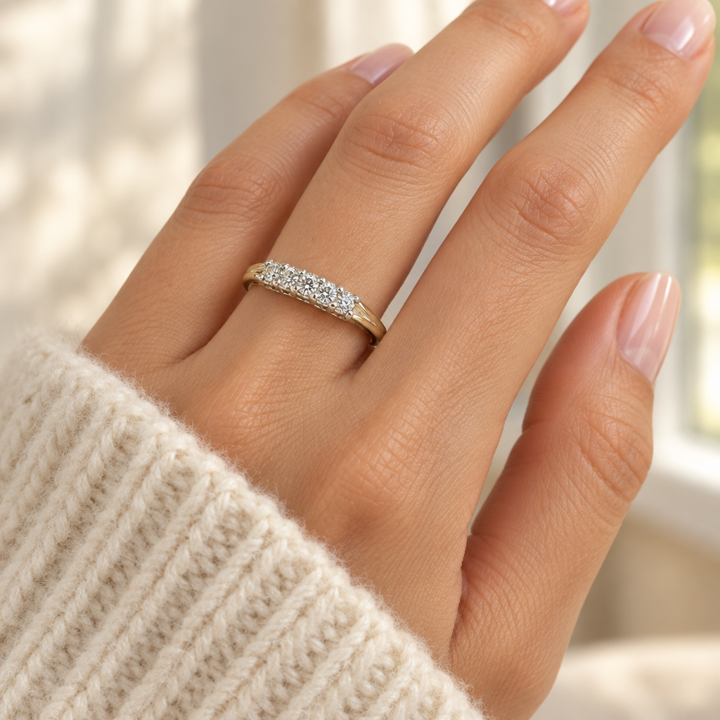 Five-stone diamond band worn on a woman's hand