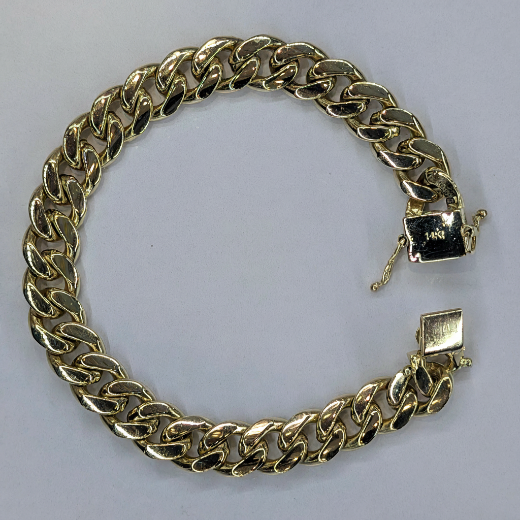 14K Yellow Gold Cuban Link Bracelet flat lay on white marble