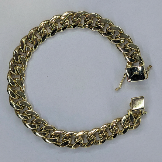 14K Yellow Gold Cuban Link Bracelet flat lay on white marble