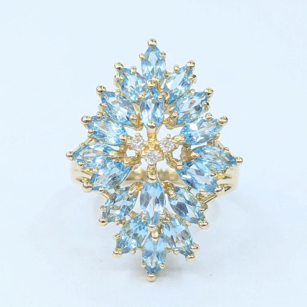 Front view of a 14K yellow gold ring with an elongated cluster of marquise-cut aquamarines and small round diamonds