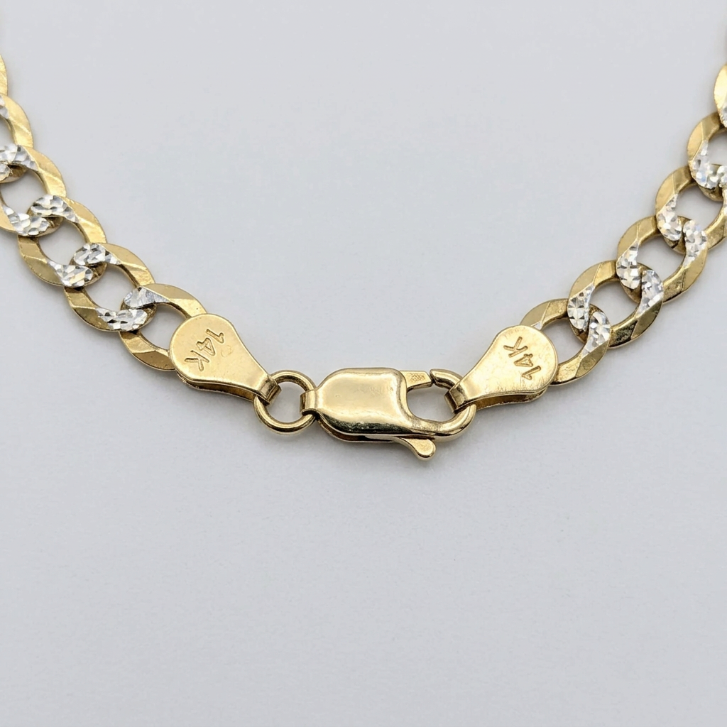 Close-up of lobster clasp and diamond-cut curb links on a 14K yellow gold bracelet
