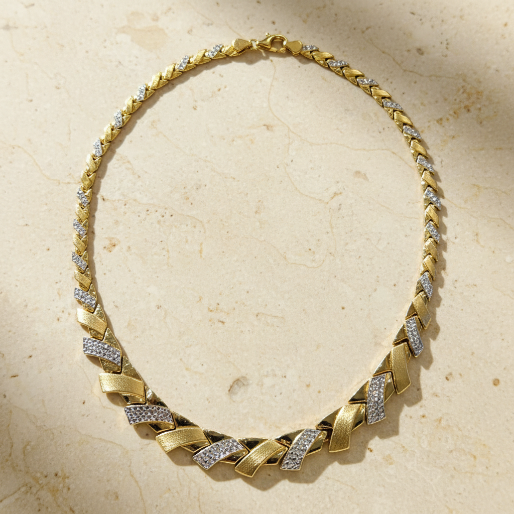 10K yellow gold crystal leaf statement necklace arranged on warm ivory stone