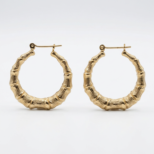 Pair of 14K yellow gold bamboo hoop earrings on white