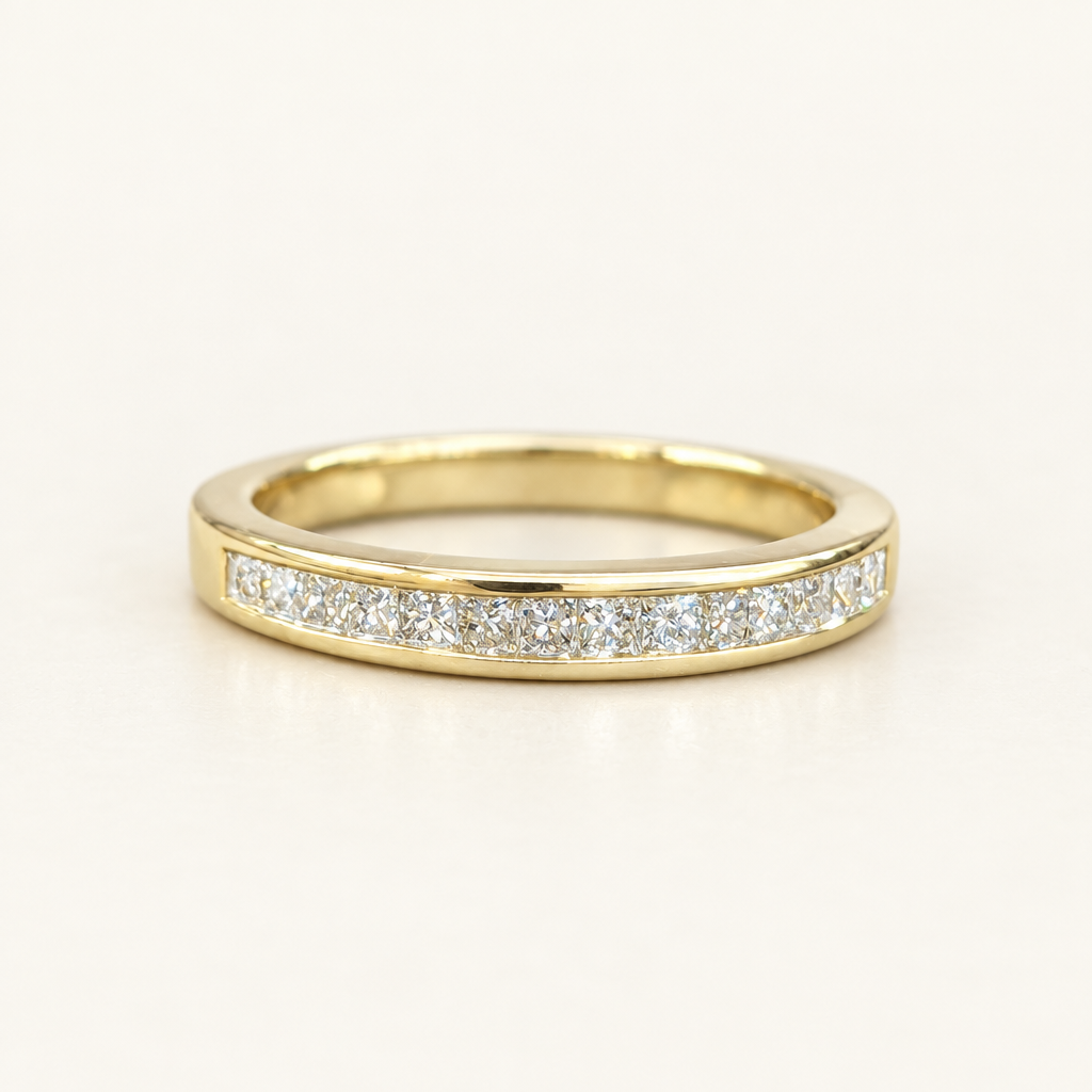 Front detail of natural diamonds in a 10K yellow gold channel-set band
