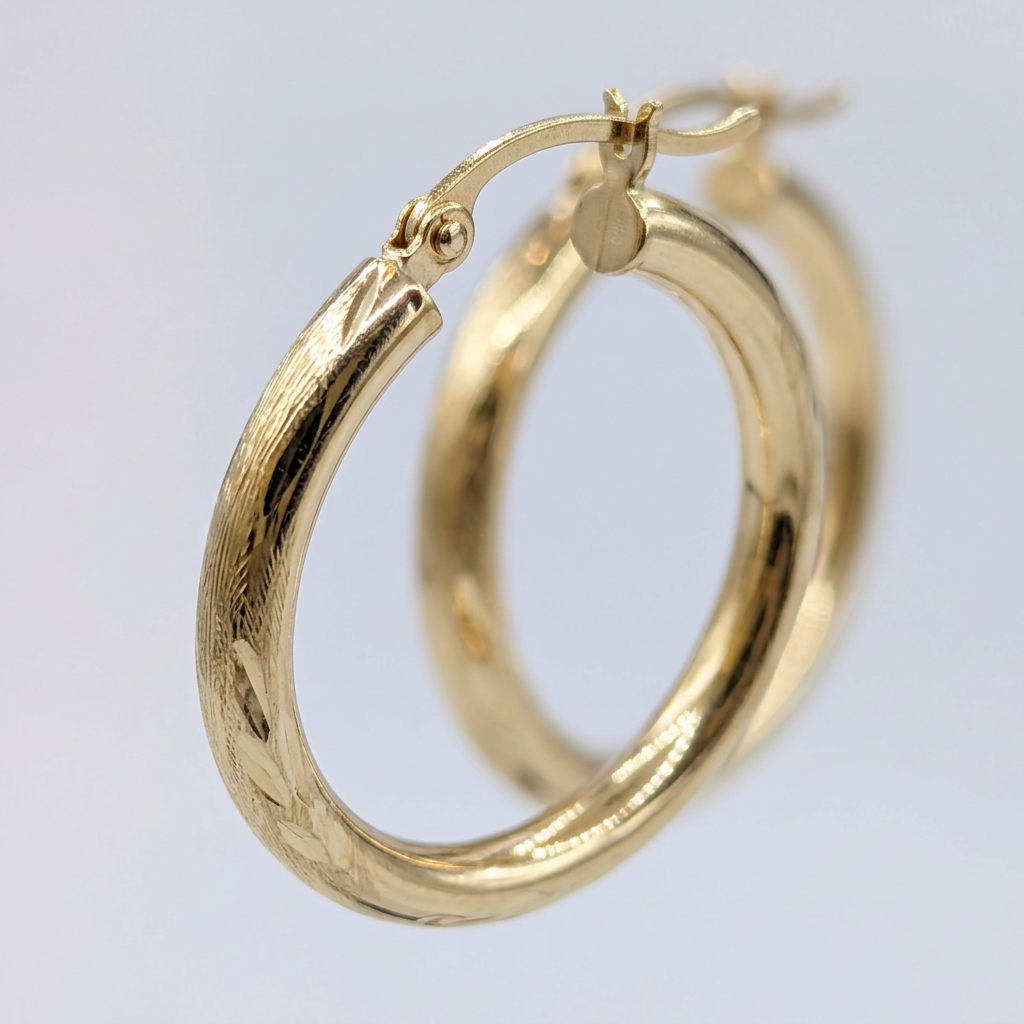 Detail of G280 patterned yellow gold hoops and hinged closure