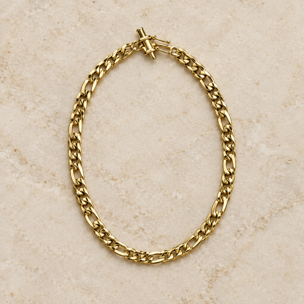 9-inch yellow gold Figaro bracelet arranged on ivory stone