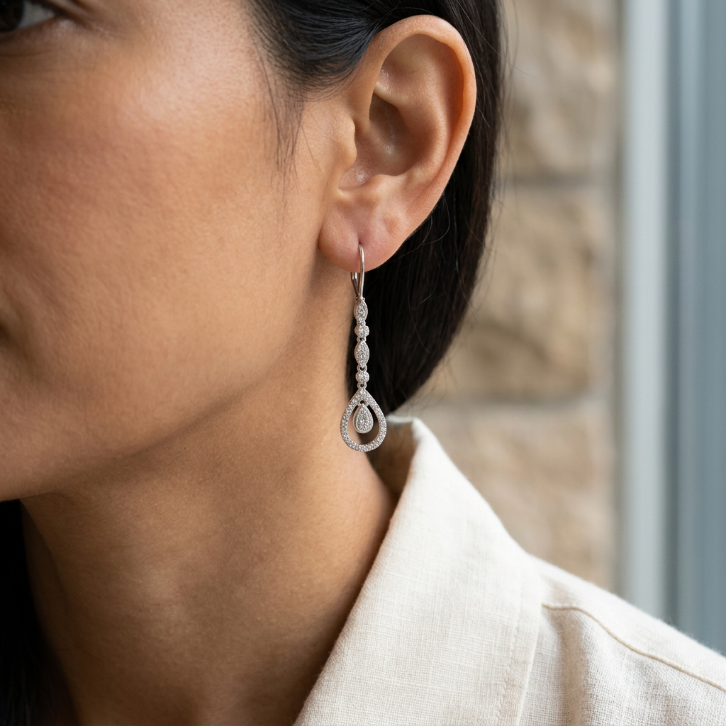 White gold diamond teardrop earring worn on the ear