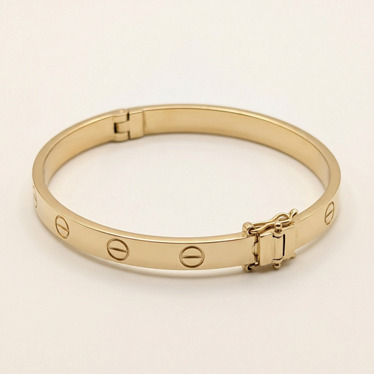 14K yellow gold screw-motif bangle, angled studio view