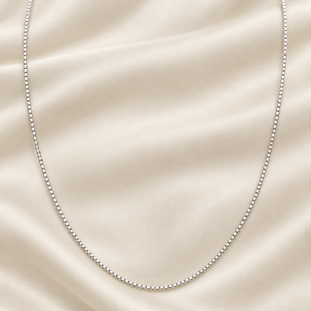 24-inch white gold box link chain on cream silk