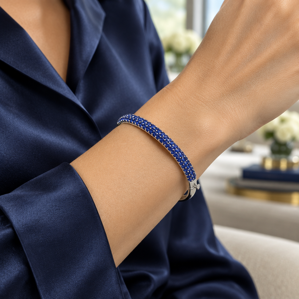 Woman wearing a 4.5mm blue sapphire and 14K white gold bangle