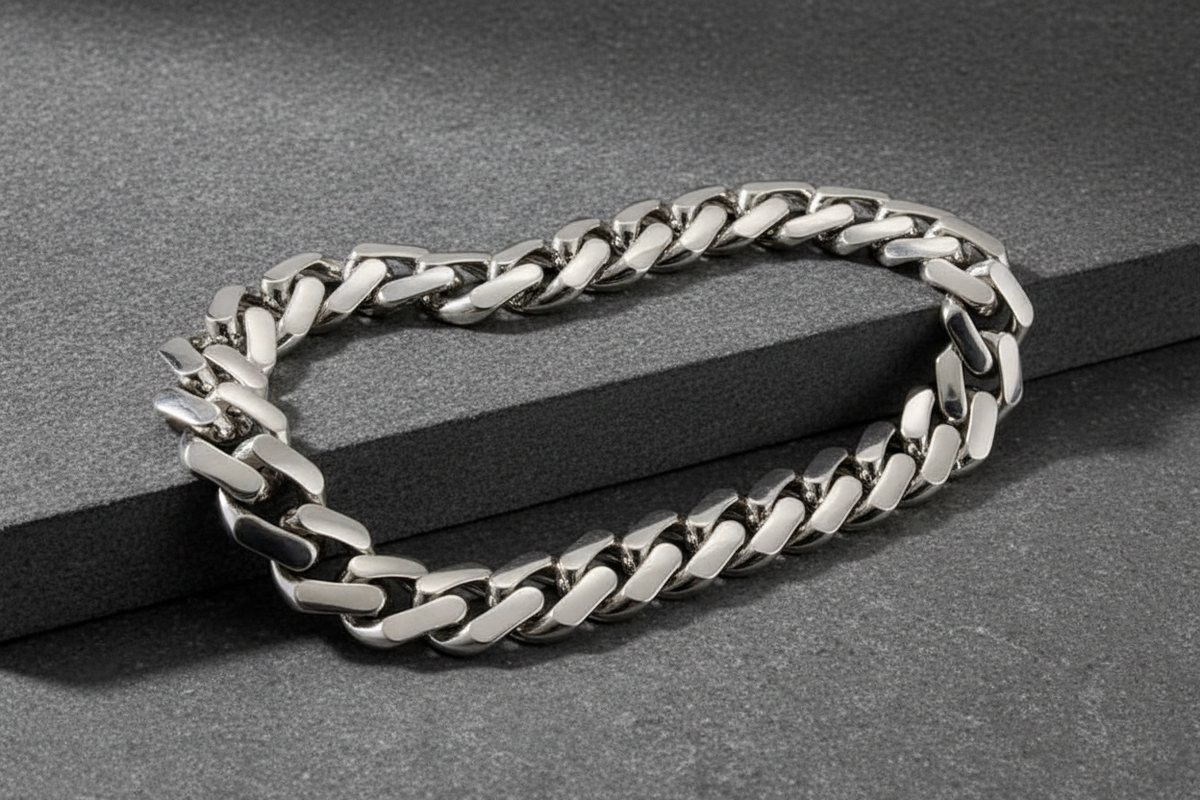 18K white gold Miami Cuban link chain draped over a charcoal stone surface