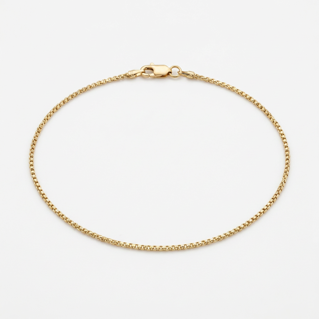 10K yellow gold round box link anklet arranged in an oval on white
