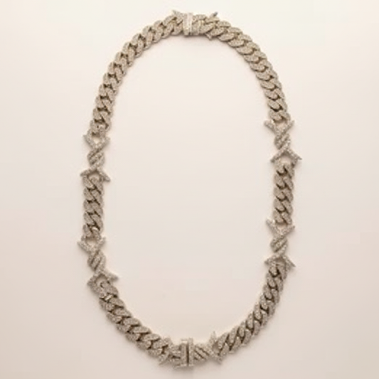 10K white gold diamond Cuban-link chain arranged in an oval on a warm white studio background