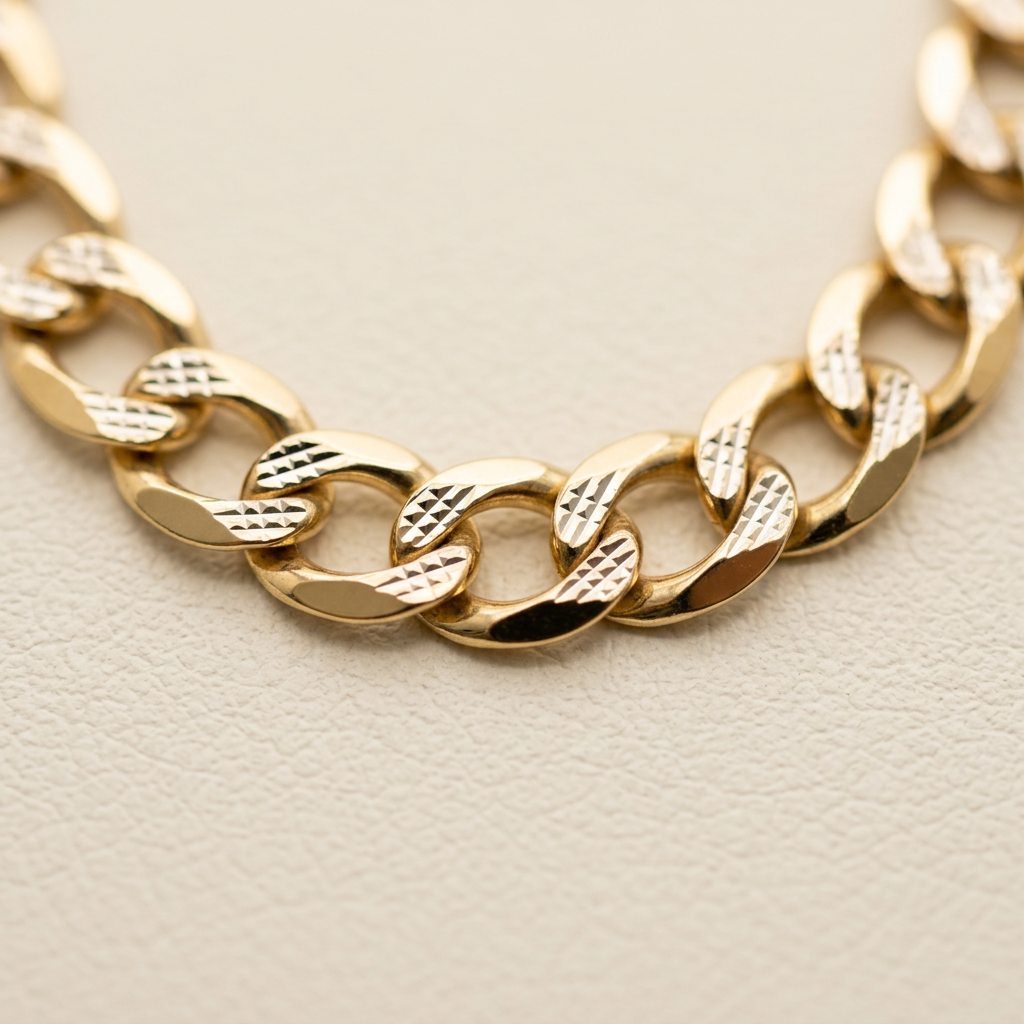 Close-up of polished and diamond-cut textures on yellow gold curb links